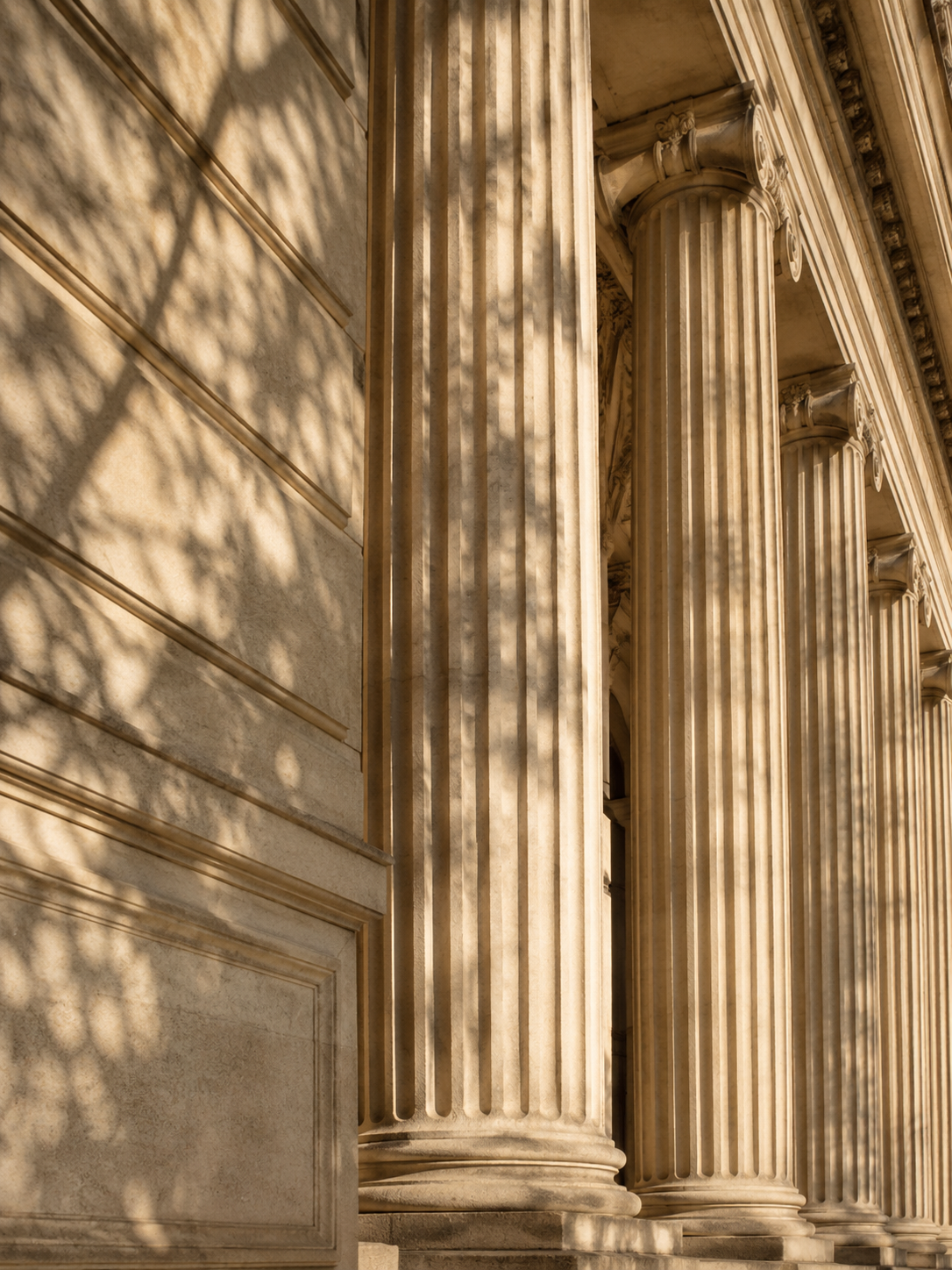 Façade de pierre et colonnes baignées d’une lumière douce